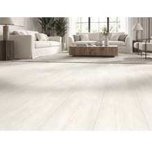 Salon lumineux avec un revêtement de sol clair à l'aspect bois, des canapés blancs et une table basse en bois.