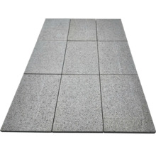 Neun rechteckige Terrassenplatten aus Granit mit strukturierter Oberfläche, im Raster von drei mal drei verlegt.