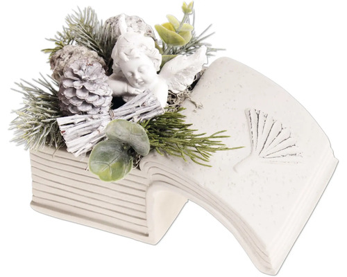 Décoration de table de Noël avec figurine d ange dans un livre ouvert en pierre avec des branches de sapin et des pommes de pin