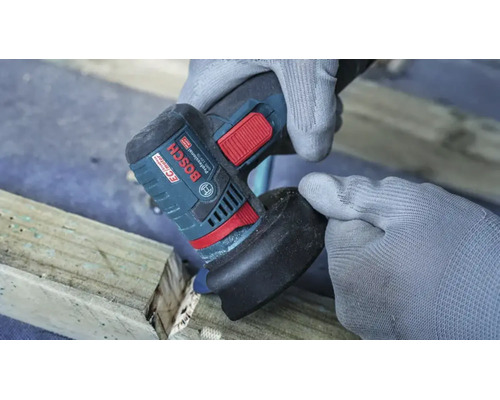 Une personne gantée utilise une meuleuse d angle Bosch pour travailler une poutre en bois.