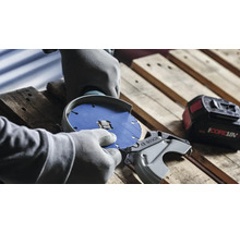 Personne avec des gants changeant le disque de tronçonnage d une meuleuse d angle sans fil Bosch sur une palette en bois