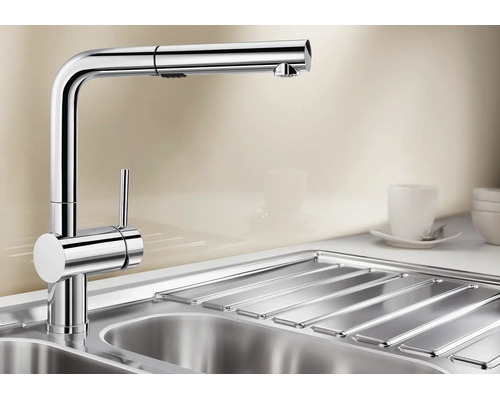 Moderne Küchenarmatur mit ausziehbarer Brause aus Metall in einer Spüle.