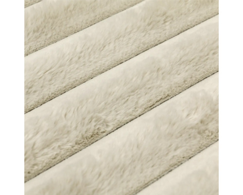 Strukturierte Oberfläche einer weichen Wohndecke mit diagonalem Streifenmuster.