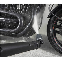 Buse de nettoyeur haute pression nettoyant un moteur de moto avec un jet d eau.