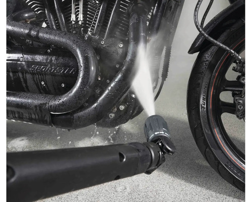 Buse de nettoyeur haute pression nettoyant un moteur de moto avec un jet d eau.