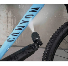 Nettoyage de vélo avec une buse haute pression pulvérisant de l eau sur le cadre du vélo