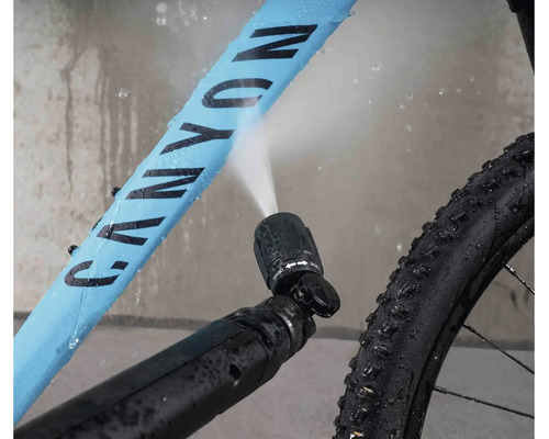 Nettoyage de vélo avec une buse haute pression pulvérisant de l eau sur le cadre du vélo