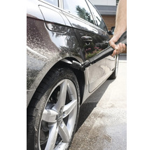 Une personne nettoie le passage de roue d une voiture avec un nettoyeur haute pression et une buse Kärcher spéciale pour l entretien automobile.