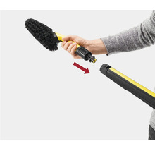 Une main montre comment raccorder une brosse de lavage Kärcher à un tube de nettoyage