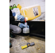 Person befüllt mit Schutzhandschuhen eine kleine Kärcher Flasche mit Reinigungsmittel aus einem großen Kärcher Kanister.