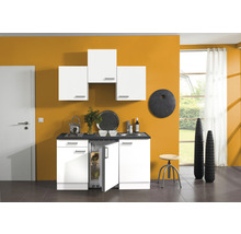 Cuisine compacte avec placards blancs, évier et réfrigérateur dans une pièce lumineuse.