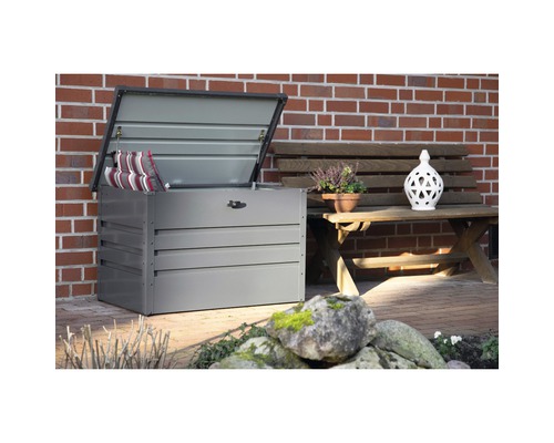 Geöffnete Gartenbox mit Kissen neben einer Gartenbank