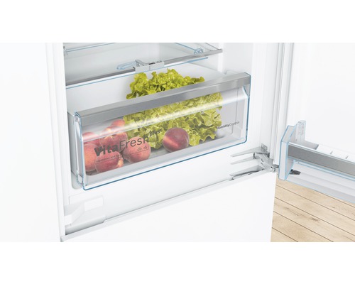 Innenraum eines Kühlschranks mit VitaFresh Schublade gefüllt mit Salat und Pfirsichen.