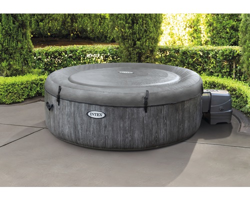 Jacuzzi gonflable rond avec couverture et pompe dans le jardin.