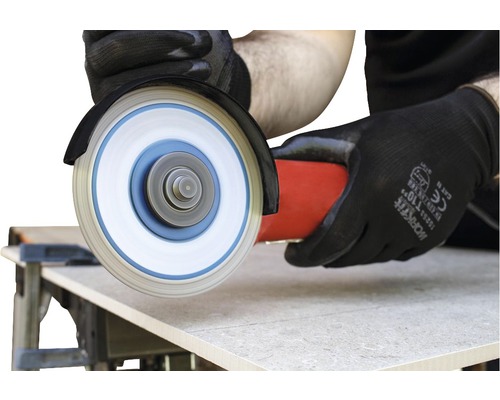 Une tuile est coupée à la taille avec une meuleuse d''angle.