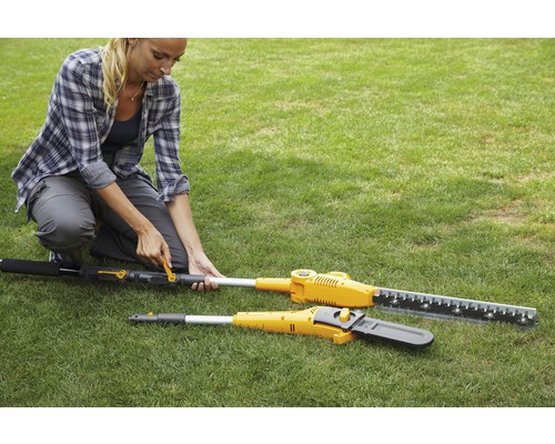 Une femme utilise un taille-haie extensible et une tronçonneuse sur une pelouse.
