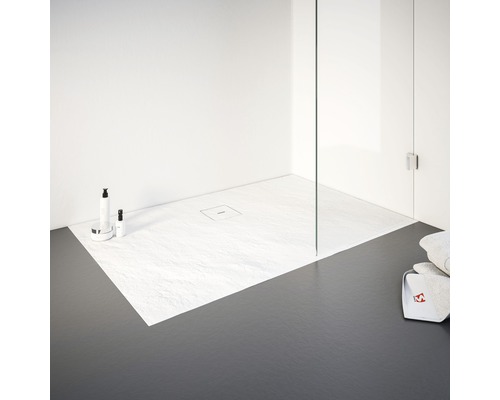 Begehbare Dusche mit flacher Duschwanne und Glasabtrennung in einem hellen Badezimmer.