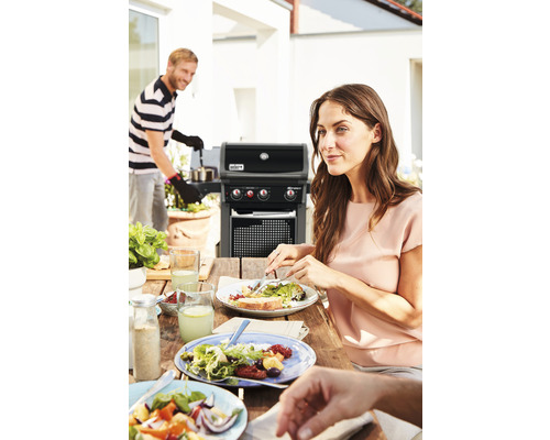 Grillszene mit Personen beim Essen im Freien und Gasgrill