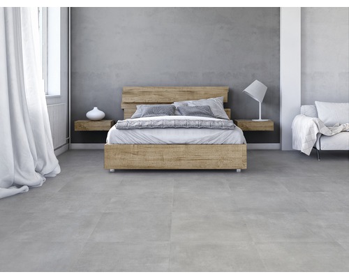 Chambre avec lit en bois, tables de chevet et carreaux de sol gris.