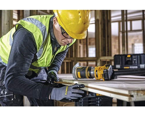 Un artisan travaille une planche de bois avec une défonceuse DeWalt