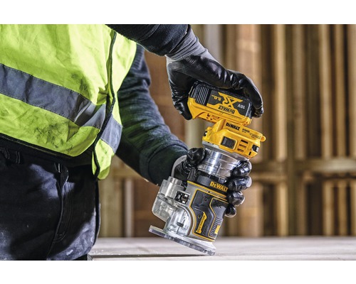 Une personne fixe une batterie sur une défonceuse Dewalt