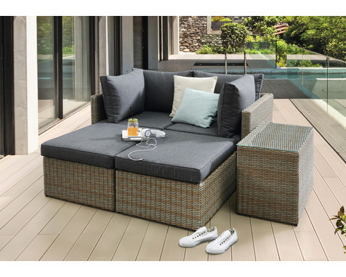 Ensemble de salon en rotin avec coussins, boisson et casque sur terrasse