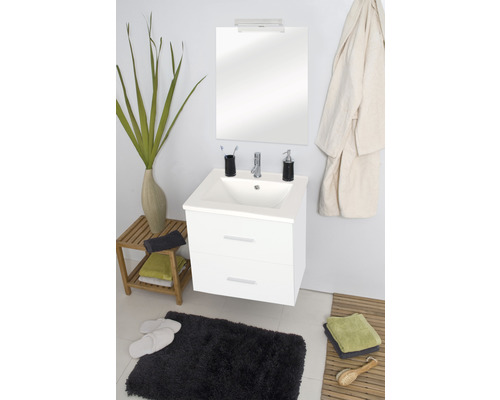 Helles Badezimmer mit weissem Waschbeckenunterschrank, Spiegel und Badtextilien.