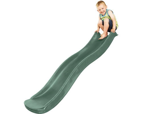 Enfant assis en haut d''un toboggan vert