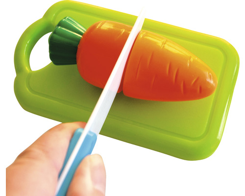 Couteau jouet coupant une carotte jouet sur une planche à découper