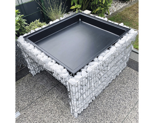 Foyer de cheminée en gabion avec foyer noir et pierres blanches