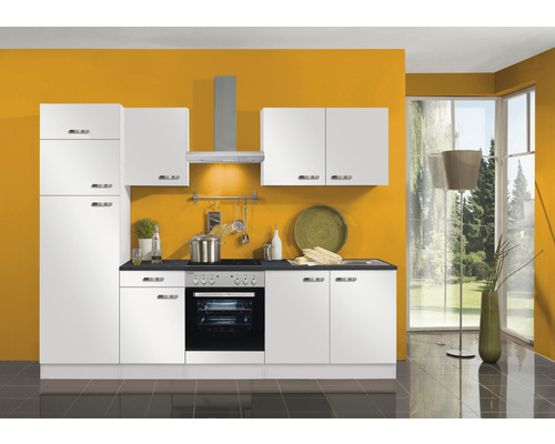 Cuisine complète avec armoires blanches, hotte aspirante et appareils électriques devant un mur coloré.