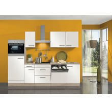 Cuisine intégrée moderne avec armoires blanches, appareils en acier inoxydable et plans de travail clairs devant un mur ocre