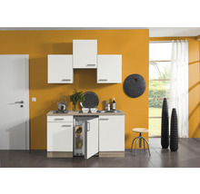 Cuisine compacte avec réfrigérateur, plaque de cuisson, évier et placards suspendus dans une pièce lumineuse.