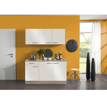 Cuisine avec évier, plaque de cuisson et armoires murales devant un mur ocre