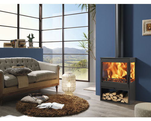 Salon avec poêle à bois, canapé et grande fenêtre avec vue