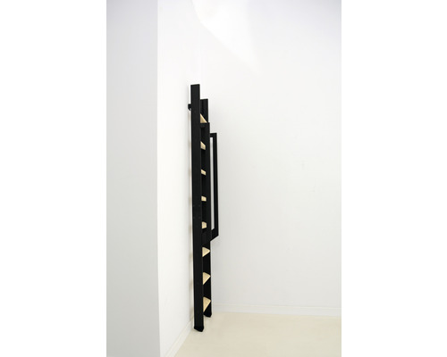 Schwarzes Leiterregal aus Holz an einer weißen Wand