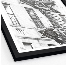 Photographie en noir et blanc d''un bâtiment avec une échelle de secours dans un cadre