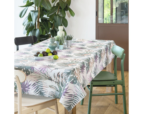 Table à manger avec une nappe à motifs tropicaux, décorée de fruits et de plantes