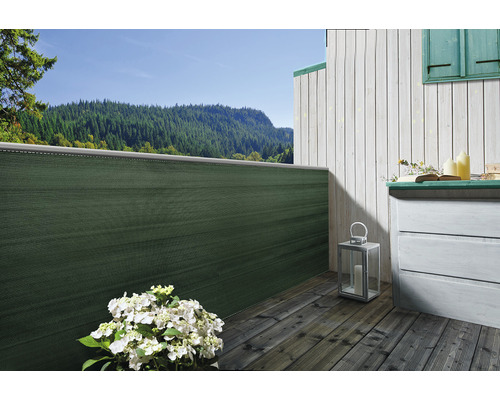 Balcon avec brise-vue, planches en bois et commode avec paysage de montagne en arrière-plan