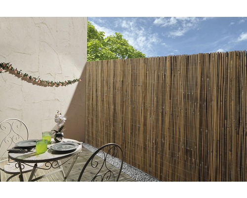 Paravent en bambou sur un balcon avec table de jardin et décoration