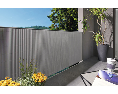 Sichtschutzwand auf einem Balkon mit Pflanzen und Möbeln.