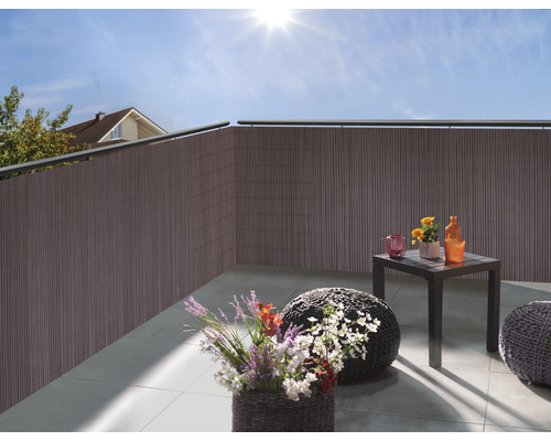 Balcon avec pare-vue, table et décorations pour une ambiance chaleureuse