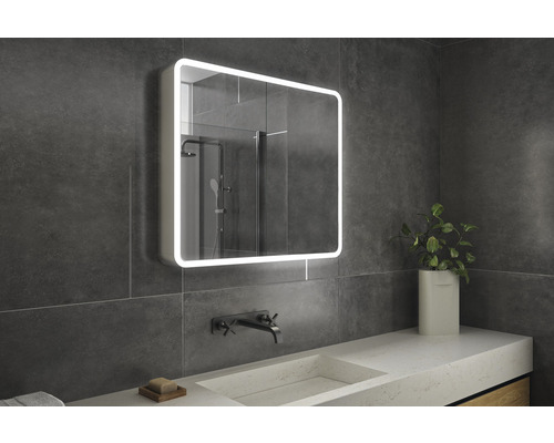 Badezimmer mit beleuchtetem Spiegelschrank, Waschtisch und Armatur.