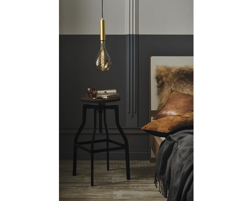 Schlafzimmer Szene mit Pendelleuchte über einem Hocker, Büchern und einem Glas