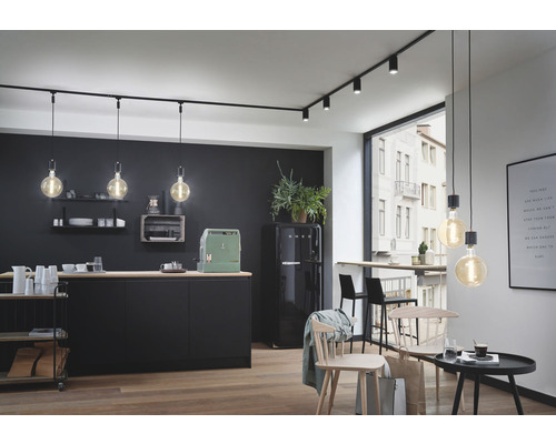 Moderne Küche mit schwarzer Küchenzeile, Esstisch und Schienenbeleuchtung