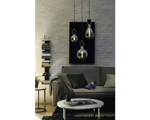 Wohnzimmer mit Sofa, Tisch und Pendelleuchte mit drei Leuchten