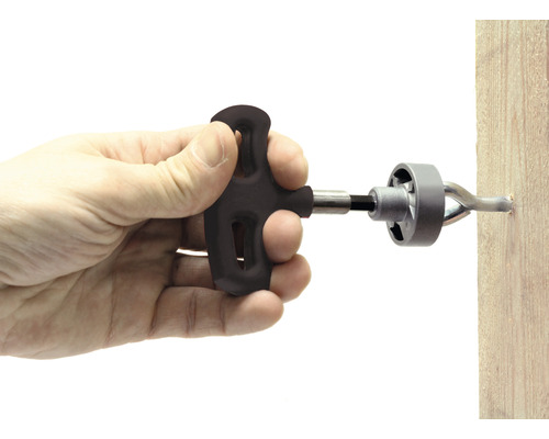 Hand verwendet ein Werkzeug zum Befestigen eines Haken an einer Holzoberfläche