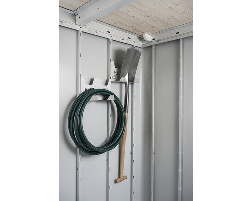 Tuyau d''arrosage et bêche sur un support à outils dans une remise de jardin