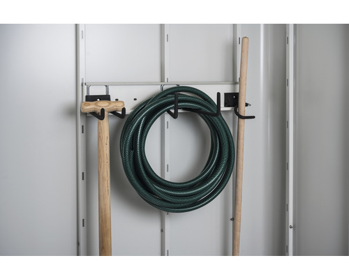 Tuyau d''arrosage, bêche et manche sur un support d''outils