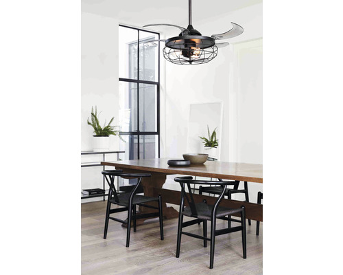 Esszimmer mit Deckenventilator in Käfigoptik und Holztisch mit Stühlen.